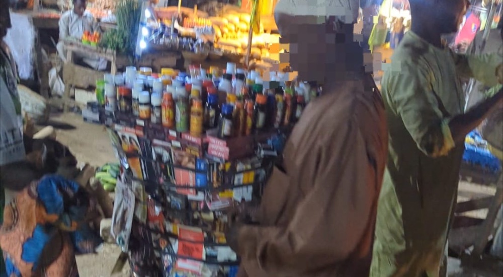 An elderly man selling drugs and herbal concoctions to a customer in Sabon Titi, Kano. PC: Lukman Abdulmalik.